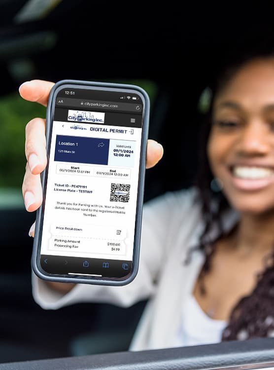 woman in car holding phone showing parking app